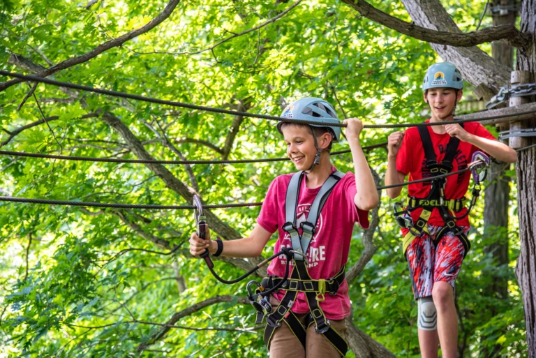 Children navigating aerial obstacles at Treetop Trekking Hamilton, an outdoor adventure park in the Hamilton area of Ontario